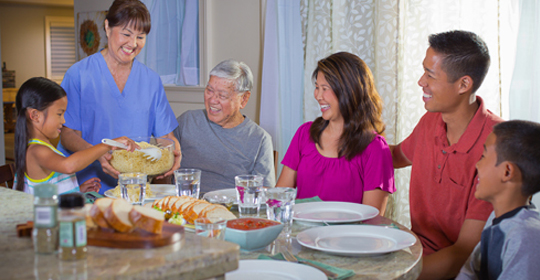 home caregiver assisting with family meals